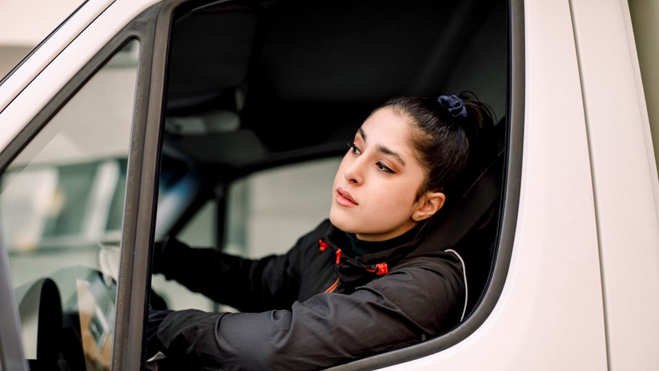 Ung kvinna i förarsätet på en lastbil
