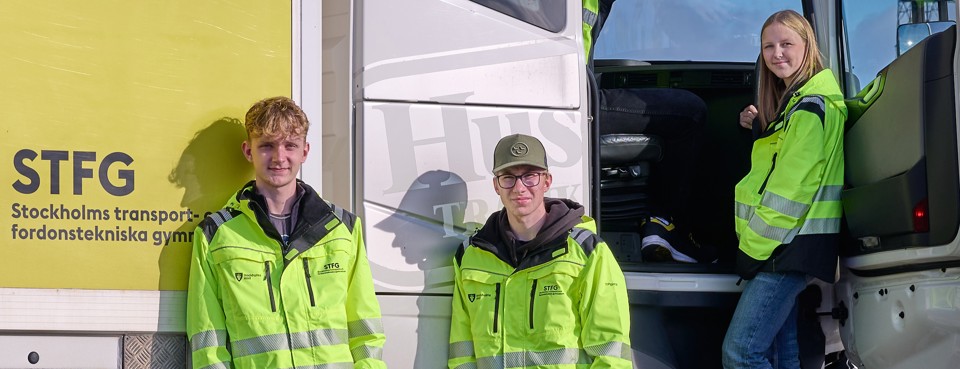 Tre elever står utanför en lastbilshytt.