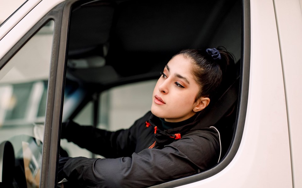Ung kvinna i förarsätet på en lastbil